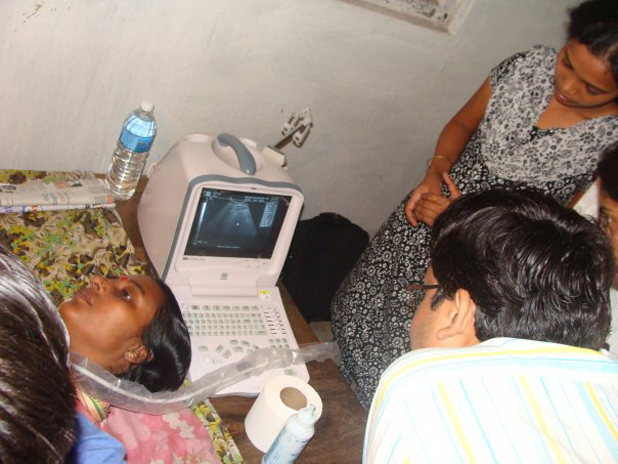 Curious students look on at a portable ultrasound system being used during a rural health camp in Midnapore, West Bengal, India. The camp was organized by student volunteers from the Engineering in Medicine and Biology (EMB) Student Club of the Indian Institute of Technology (IIT) Kharagpur. (Photo courtesy of the IEEE EMB Student Club of IIT Kharagpur.)