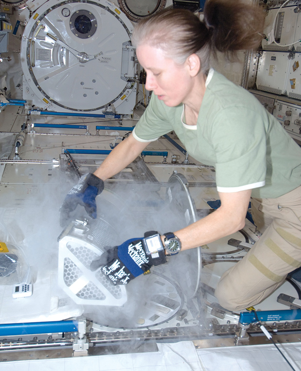 NASA astronaut Shannon Walker services the Minus Eighty Laboratory Freezer for ISS in this 2010 photo. The freezer is in the Kibo Laboratory, which is the Japanese science module. The Japan Aerospace Exploration Agency is among the five space agencies participating in the ISS program. (Photo courtesy of NASA .)