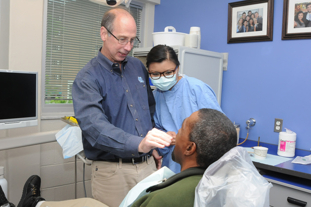 When combined with different modeling computer formats, digital scans can produce accurate 3D images at the bone and surface levels. New capabilities are now adding the extra-oral environment, including the nose, lips, and other facial features, to produce “an entire digital patient,” days Lyndon Cooper, who is shown here working with a patient. Photo credit: Ramona Hutton-Howe, UNC School of Dentistry.