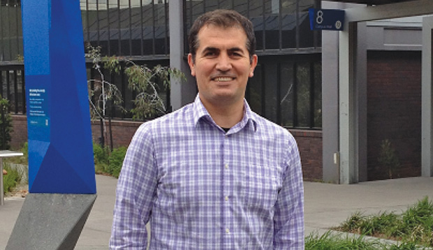 FIGURE 4: Mehmet Yuce, an academic member of electrical and computer systems engineering at Monash University in Victoria, Australia, in front of the building that houses the lab where he and his research group are designing low-power integrated circuits, or microchips, that can harvest energy from body vibration, electromagnetism, and/or the piezoelectric effect the body generates as people go about their daily activities. (Photo courtesy of Mehmet Yuce.)