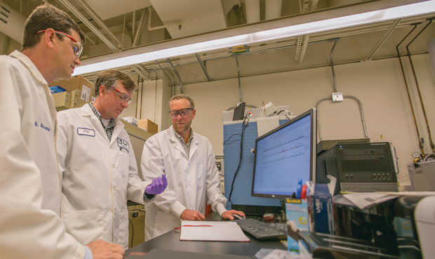 Figure 4: Parker (center) is pictured with Brad Hart (left), director of LLNL’s Forensic Science Center, and chemist Deon Anex. All three are involved in the hair-protein-identification technology, which centers on a class of DNA mutations that result in sequence changes within hair proteins. (Photo courtesy of Julie Russell/LLNL.)