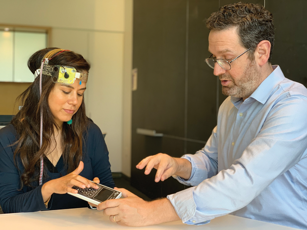 Figure 4. At his lab at The City University of New York (CUNY), Dr. Marom Bikson demonstrates the use of Soterix Medical home-based tDCS, which patients reliably self-apply using autopositioning headgear and snap-on electrodes (called “Snap Pads”). Clinicians—— or researchers, if part of a research project—— are able to personalize the stimulation to the individual patient and control the dose. They are also able to access devicecollected data from the patient. (Photo courtesy of CUNY.)